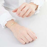 Dieses Foto zeigt ein Tragebeispiel des Armbands mit Gravurplatte aus 333er Gold