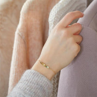 Dieses Foto zeigt ein Tragebeispiel des Armbands mit Gravurplatte aus 375er Gold